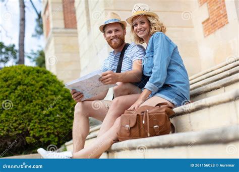 Pareja De Turistas Sentados En Los Escalones Mirando El Mapa De La