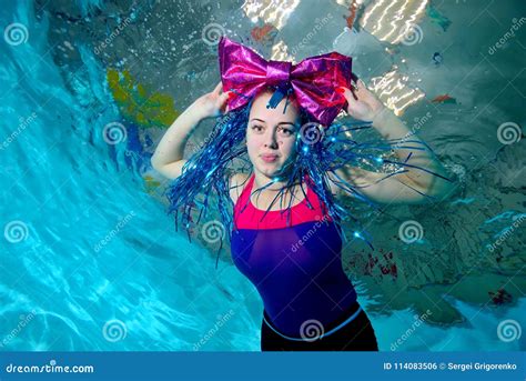 Young Girl With Large Bow Clown On The Head Swims In The Pool