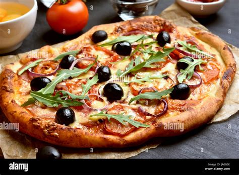 Pizza With Tomato Salami And Olives Close Up View Stock Photo Alamy