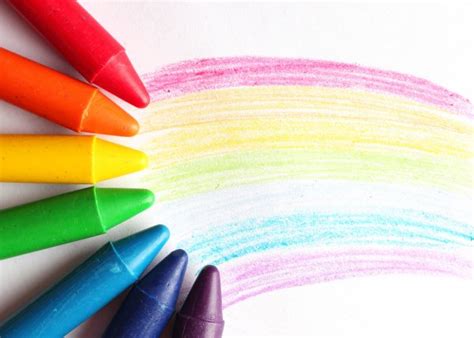 Oil Pastel Crayons Lying On A Paper With Painted Rainbow Stock Photo