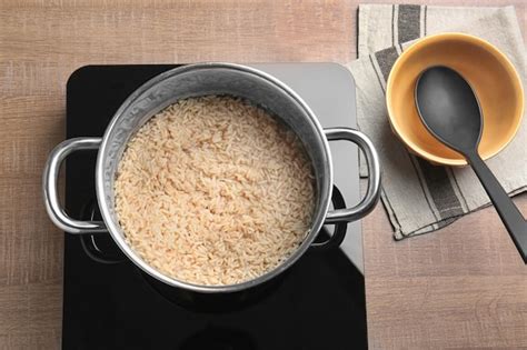 Premium Photo | Saucepan with brown rice on stove