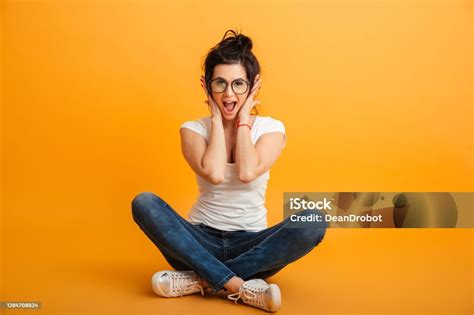 Goodlooking Girl 20s Wearing Eyeglasses Sitting With Legs Crossed On