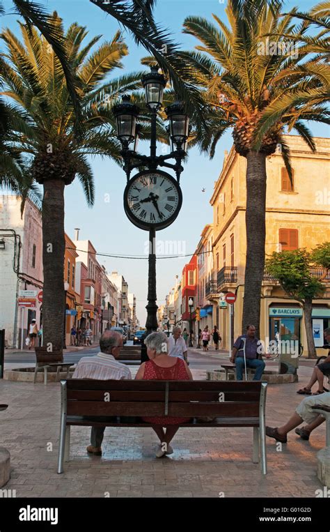 Menorca Balearic Islands A Couple On A Bench In The Town Square Of