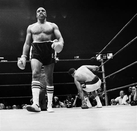 A Man Standing Next To Another Man In A Boxing Ring