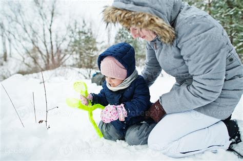 Mother with baby girl daughter in winter nature. Outdoors in snow. 11728192 Stock Photo at Vecteezy