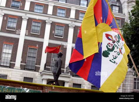 Tibetan And Chinese Flags Flying Side By Side Outside The Chinese