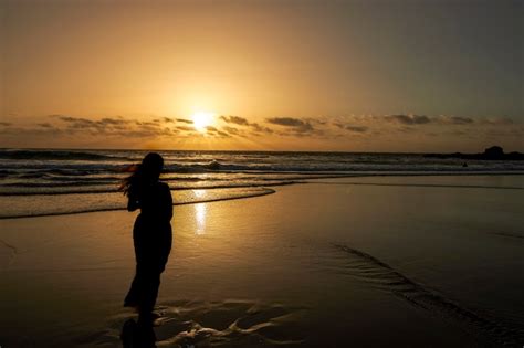 Silueta De Mujer Mirando La Puesta De Sol En La Playa Foto Premium