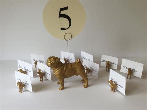 There Is A Golden Dog Figurine On The Table With Place Cards And Numbers