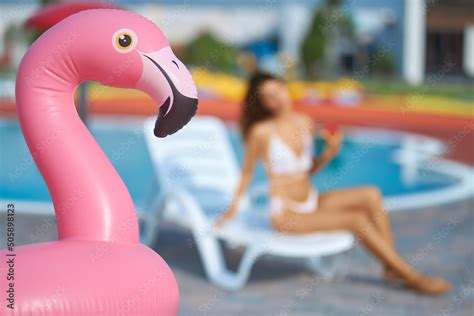 Inflatable pink flamingo ring at swimming pool area outside. Close up view of pink flamingo air ...