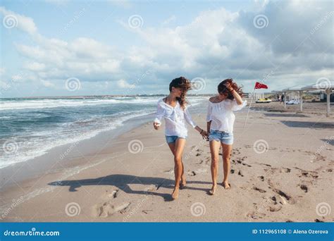 Twee Vrienden Die Op Het Strand Lopen Stock Foto Image Of Glimlach Koel 112965108