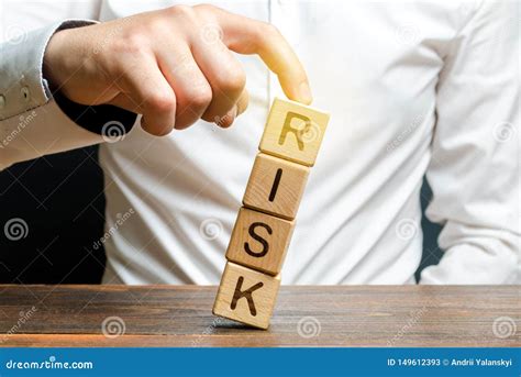 Businessman Rescues With His Finger A Tower Of Cubes With The Word Risk