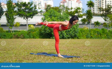 Asian Chinese Female Lady Yogi Practise Yoga Stretches Poses In The Park In Beautiful Weather