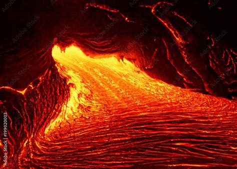 Scenic view of a part of a lava flow in the dark, the hot lava shows up ...