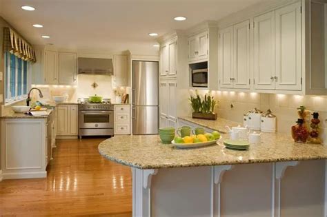 A Large Kitchen With White Cabinets And Marble Counter Tops Along With