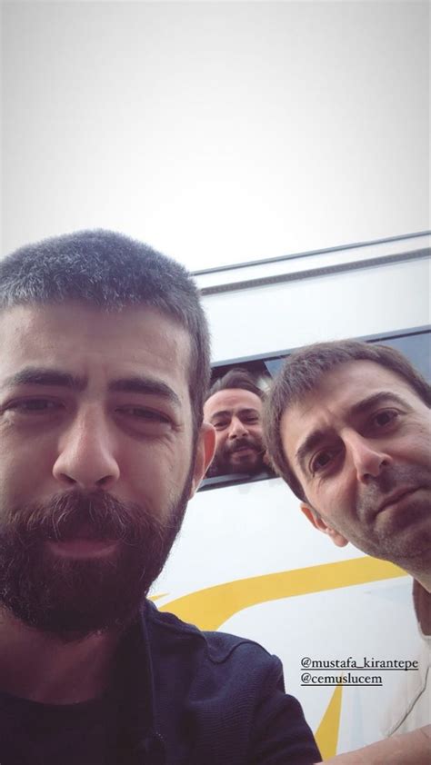 Two Men Are Taking A Selfie In Front Of A Bus With Another Man Behind Them