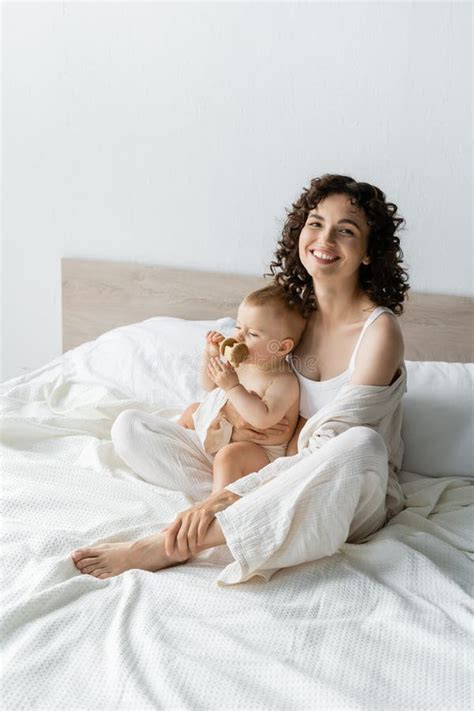 Positive Brunette Parent Hugging Baby With Stock Photo Image Of Care Bedding 256559386