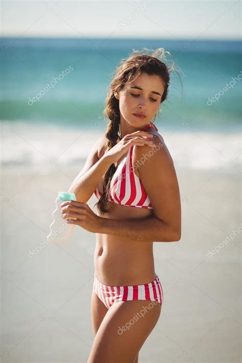 Woman Applying Sunscreen Lotion On Her Arm Stock Photo