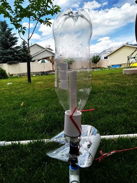 A Water Dispenser Sitting On Top Of A Lush Green Field