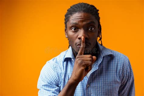 African American Man Showing Silence Gesture Over Yellow Background