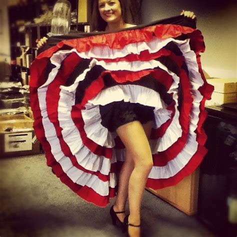 A Woman Is Holding Up A Large Red And White Umbrella