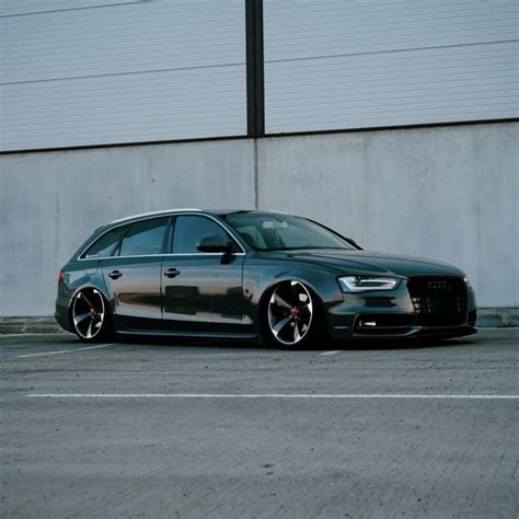 a black car parked in front of a building with no one on it's side