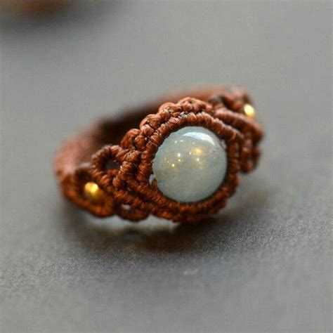 a close up of a ring on a table with beads and wire around the band