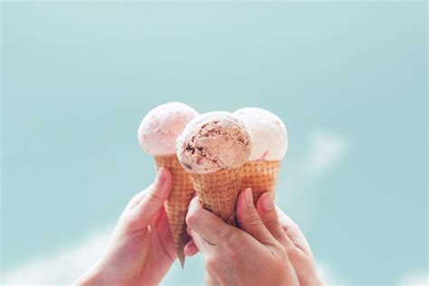 Premium Photo Young Woman Hands Holding Ice Cream Cones On Sky Summer