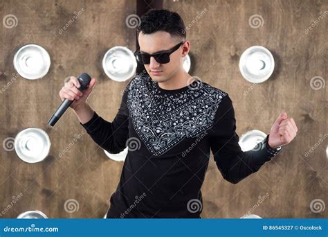 Male Rock Singer Performs On Scene In Projectors Lights Stock Image