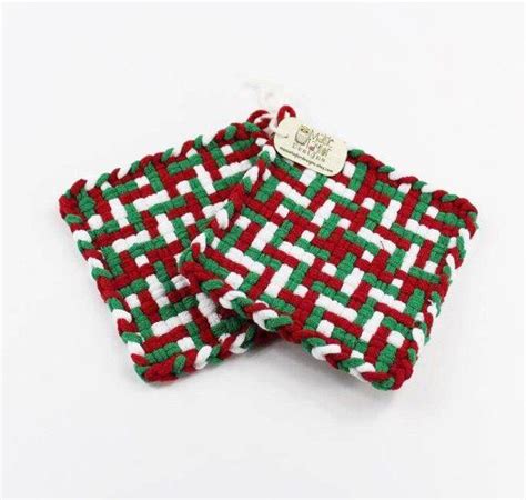 Two Red And Green Knitted Coasters Sitting Next To Each Other On A