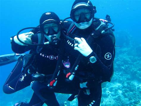 Two People In Scuba Gear Standing Next To Each Other