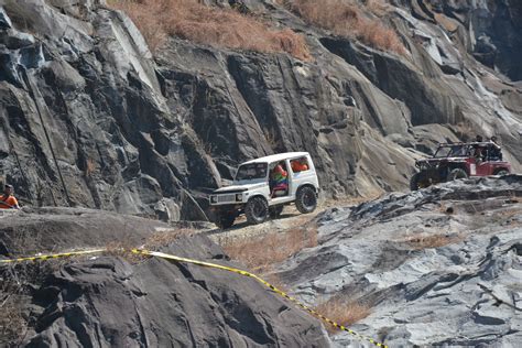 Four Jeeps Are Parked On The Side Of A Rocky Mountain Road With Yellow