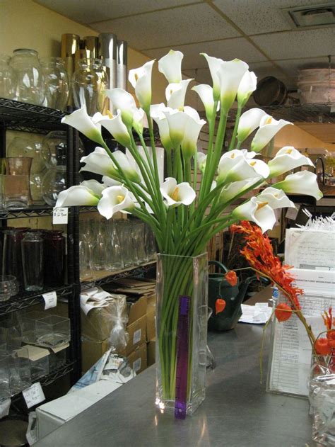 A Vase Filled With White Flowers Sitting On Top Of A Counter Next To