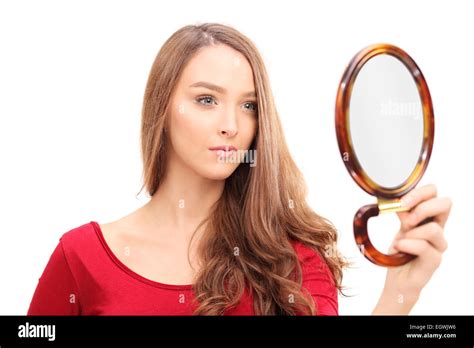 Studio Shot Of A Gorgeous Woman Looking Herself In A Mirror Isolated On