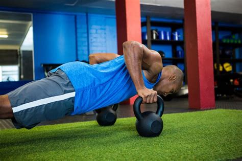 Atleta Masculino Haciendo Flexiones Con Pesas Rusas Foto Premium