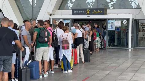 Turistas Hacen Largas Filas En La Terminal De Salidas Del Aeropuerto De