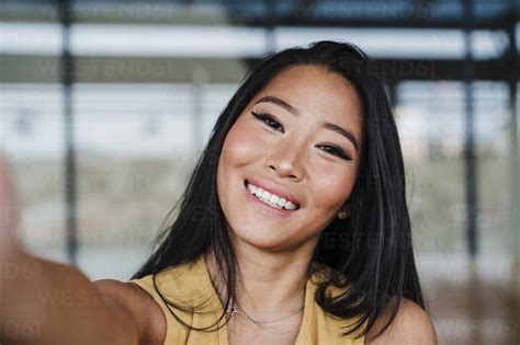 Female Professional Taking Selfie At Office Stock Photo