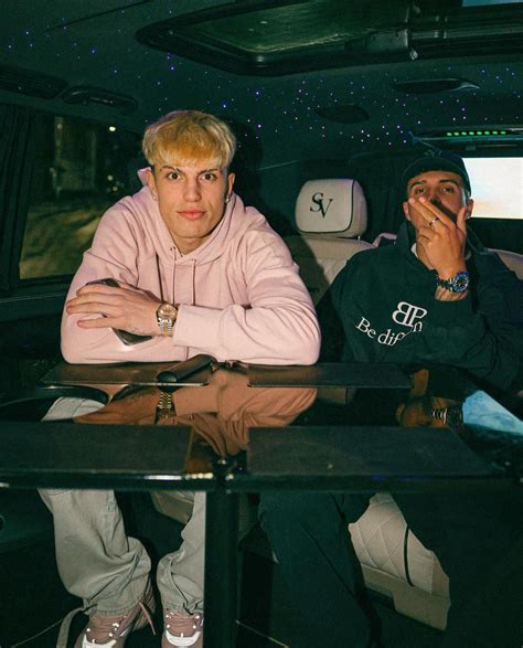 Two Men Sitting In The Back Of A Car With Their Hands On Their Chins