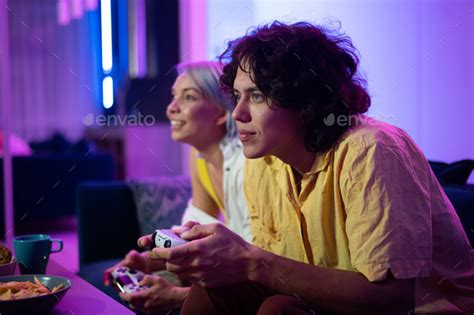 Young Cheerful Caucasian Husband And Wife Play Videogames Against Each