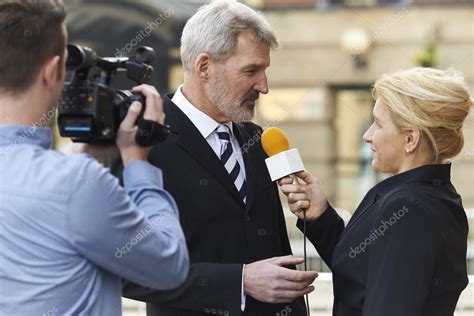 Female Journalist With Microphone Interviewing Businessman Stock