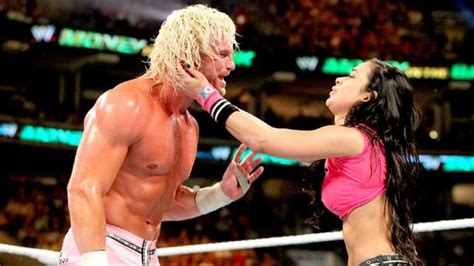 A Man And Woman Wrestling In An Arena With The Referee Looking At Eachother