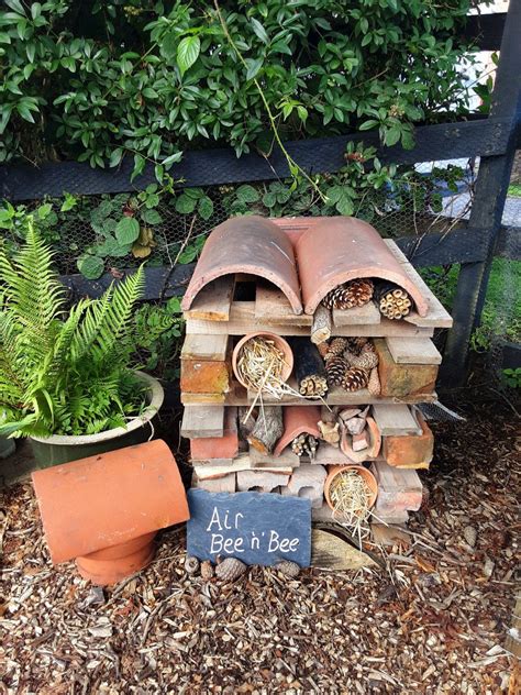 All You Need is Bees Sign with Wood Pile and Potted Plant
