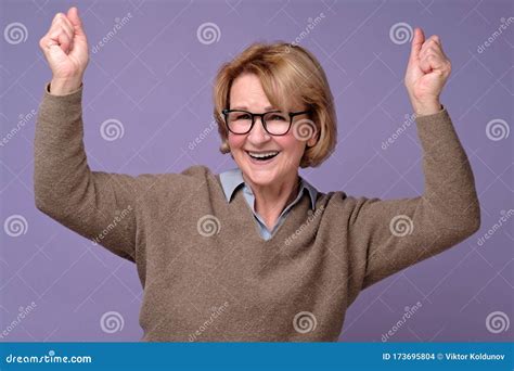 Mature Senior Woman Doing A Winner Gesture Holding Fists Up Enjoying