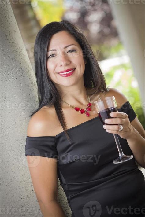 Attractive Hispanic Woman Portrait Outside Enjoying Wine 16308294 Stock