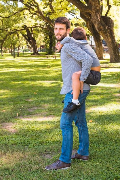 Free Photo Portrait Of A Man Giving Piggyback Ride In The Park