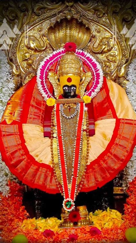 an idol is displayed in front of a gold and red backdrop with flowers on it