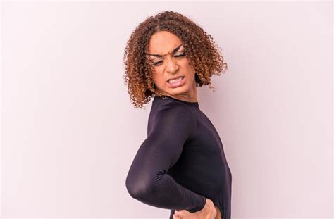 Jovem Mulher Transexual Latina Isolada Em Um Fundo Rosa Sofrendo De Uma Dor Nas Costas Foto