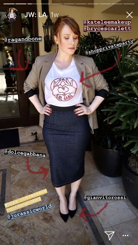 a woman standing in front of a plant wearing a t - shirt and pencil skirt