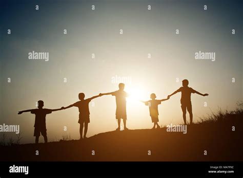 Group Of Children Silhouettes Holding Hands Together Stock Photo Alamy