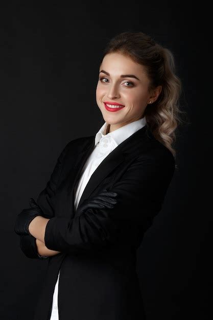 Sexy Blonde Intelligente Avec De Longs Cheveux Bouclés Pose En Veste Noire Et Des Gants Noirs
