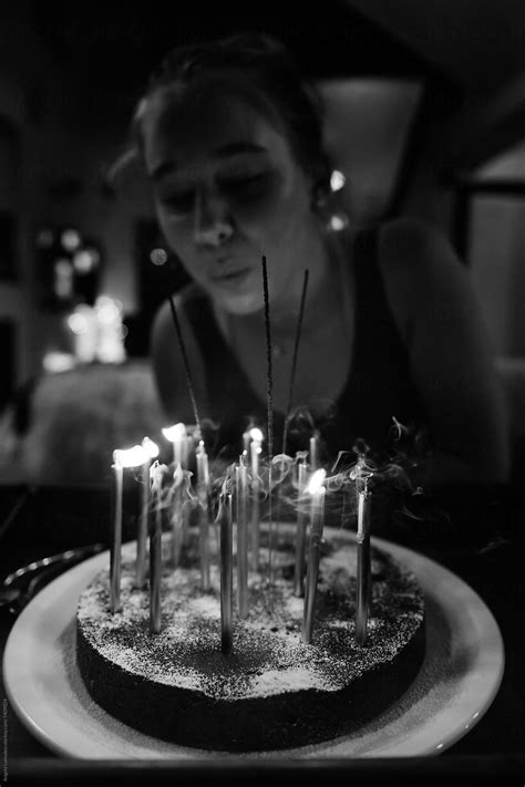 Teenage Girl Blowing Out Candles On A Birthday Cake Del Colaborador